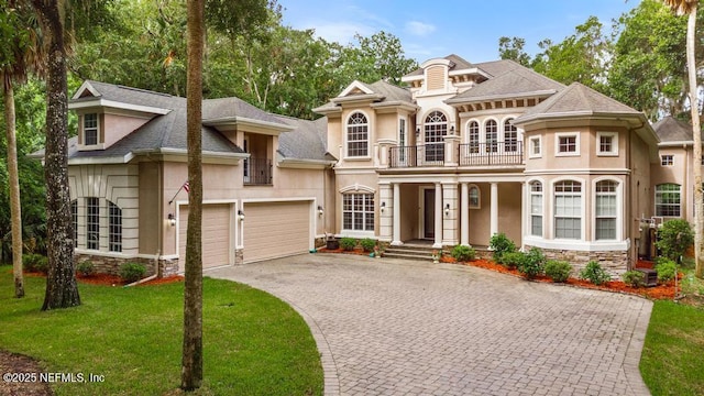 69 Bridle Ridge Ct, Flagler Beach, FL 32136 - french country inspired facade with a balcony, stucco siding, decorative driveway, and a garage