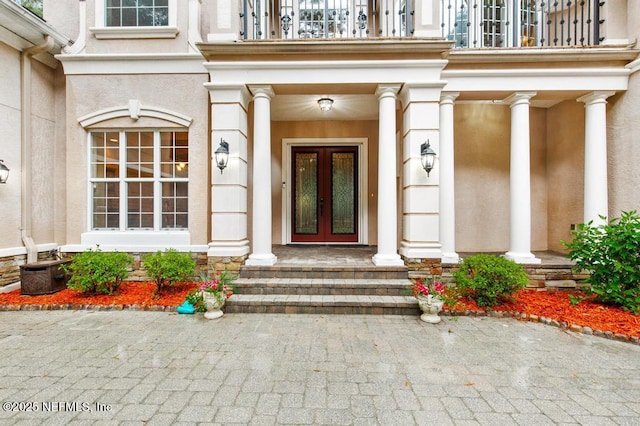 69 Bridle Ridge Ct, Flagler Beach, FL 32136 - property entrance featuring a balcony, french doors, stucco siding, covered porch, and stone siding