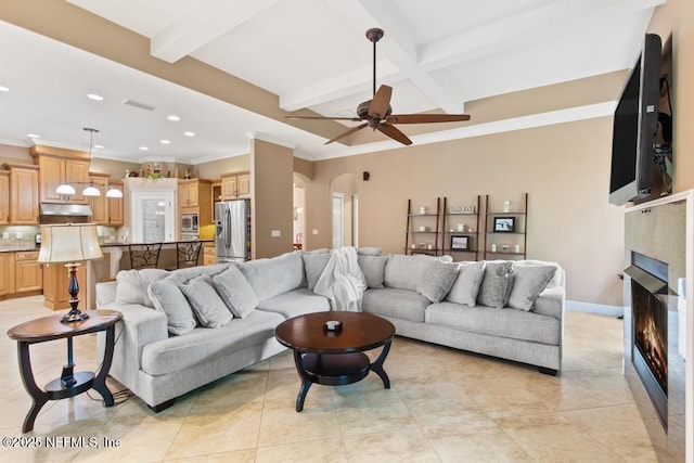69 Bridle Ridge Ct, Flagler Beach, FL 32136 - living area featuring arched walkways, beamed ceiling, recessed lighting, a lit fireplace, and a ceiling fan