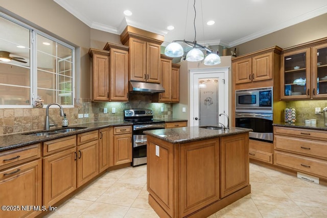 69 Bridle Ridge Ct, Flagler Beach, FL 32136 - kitchen with appliances with stainless steel finishes, a sink, under cabinet range hood, decorative backsplash, and a center island with sink