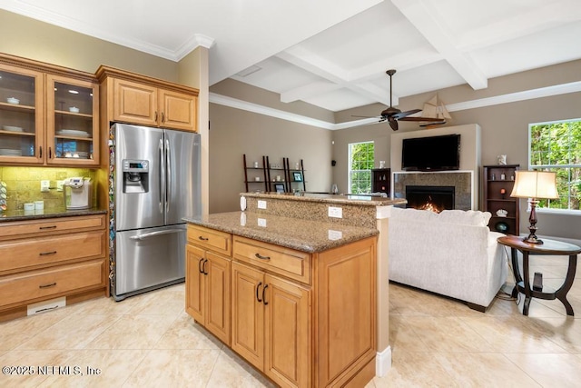 69 Bridle Ridge Ct, Flagler Beach, FL 32136 - kitchen featuring stainless steel fridge with ice dispenser, coffered ceiling, a lit fireplace, light tile patterned floors, and a center island