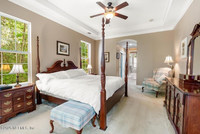 69 Bridle Ridge Ct, Flagler Beach, FL 32136 - bedroom with arched walkways, light colored carpet, multiple windows, a tray ceiling, and ornamental molding