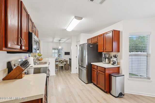 12357 Winterpine Ct, Jacksonville, FL 32225 - kitchen with appliances with stainless steel finishes, light wood-style flooring, a sink, light countertops, and baseboards