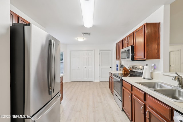 12357 Winterpine Ct, Jacksonville, FL 32225 - kitchen featuring appliances with stainless steel finishes, a sink, light countertops, and light wood-style flooring