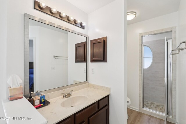 12357 Winterpine Ct, Jacksonville, FL 32225 - bathroom with vanity, toilet, a stall shower, and wood finished floors