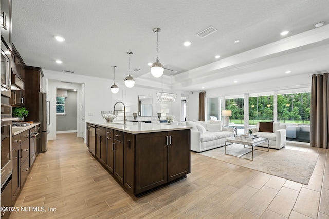 96 Glenhurst Ave, Ponte Vedra, FL 32081 - kitchen with open floor plan, dark brown cabinets, light countertops, a kitchen island with sink, and recessed lighting