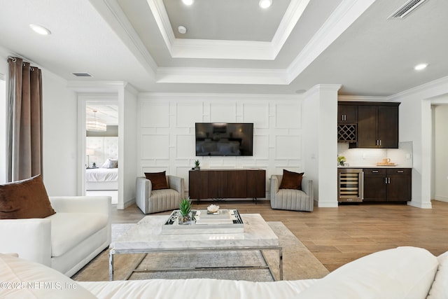 96 Glenhurst Ave, Ponte Vedra, FL 32081 - living room featuring wine cooler, bar with sink, light wood-style floors, a tray ceiling, and ornamental molding