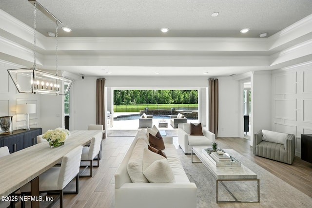 96 Glenhurst Ave, Ponte Vedra, FL 32081 - living room featuring a tray ceiling, wood finished floors, ornamental molding, a textured ceiling, and a chandelier