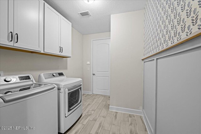 27 Shady Lake Ct, Saint Augustine, FL 32095 - washroom with washing machine and clothes dryer, cabinet space, baseboards, wood finish floors, and a textured ceiling
