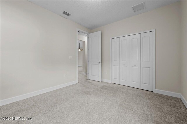 27 Shady Lake Ct, Saint Augustine, FL 32095 - unfurnished bedroom with carpet flooring, baseboards, a closet, and a textured ceiling