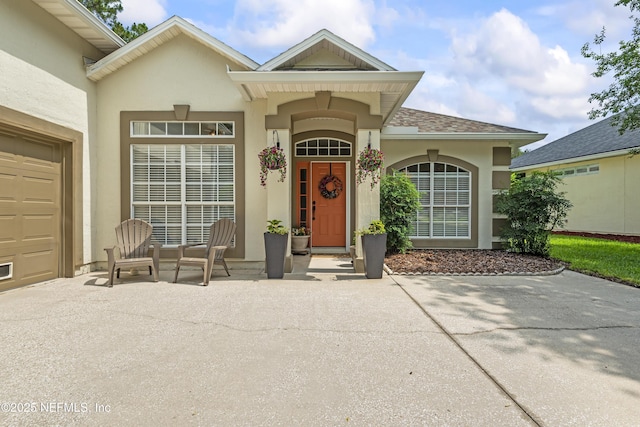 4340 Comanche Trail Blvd, Saint Johns, FL 32259 - view of exterior entry featuring stucco siding, covered porch, a garage, and concrete driveway