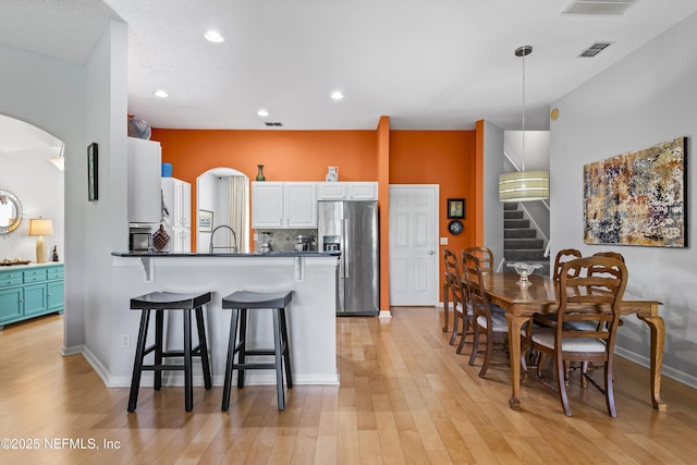 4340 Comanche Trail Blvd, Saint Johns, FL 32259 - kitchen featuring stainless steel refrigerator with ice dispenser, a kitchen breakfast bar, light wood-type flooring, a peninsula, and recessed lighting