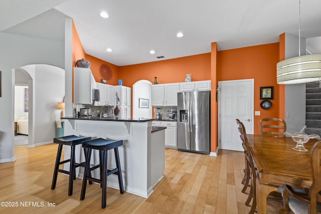 4340 Comanche Trail Blvd, Saint Johns, FL 32259 - kitchen with stainless steel appliances, arched walkways, a peninsula, a breakfast bar area, and dark countertops