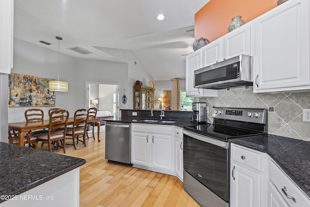 4340 Comanche Trail Blvd, Saint Johns, FL 32259 - kitchen featuring appliances with stainless steel finishes, a peninsula, lofted ceiling, backsplash, and white cabinets