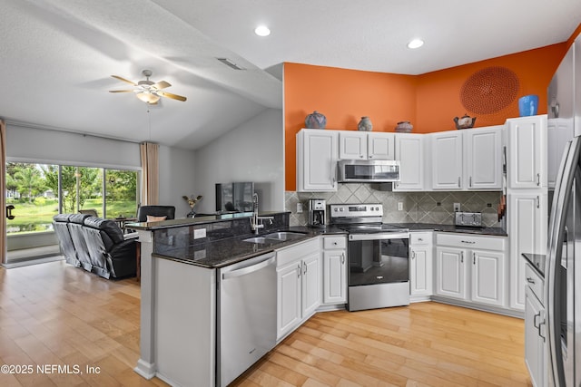 4340 Comanche Trail Blvd, Saint Johns, FL 32259 - kitchen with appliances with stainless steel finishes, a peninsula, light wood finished floors, open floor plan, and white cabinets