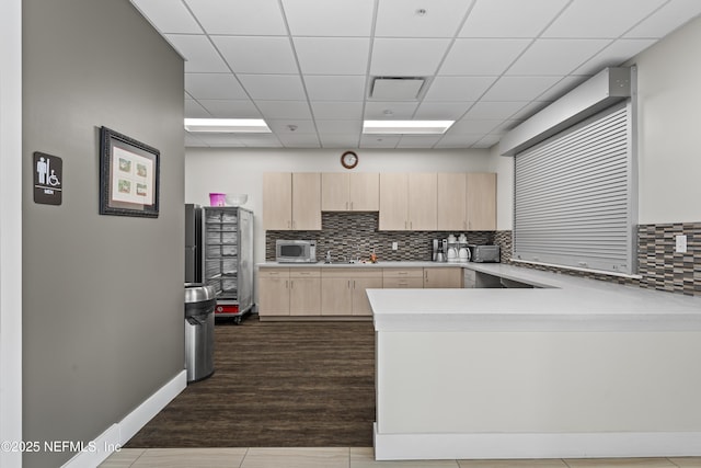 4340 Comanche Trail Blvd, Saint Johns, FL 32259 - kitchen featuring light brown cabinetry, stainless steel microwave, light countertops, a peninsula, and tasteful backsplash