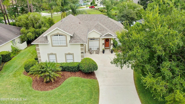 4340 Comanche Trail Blvd, Saint Johns, FL 32259 - view of front facade featuring concrete driveway, a shingled roof, a front lawn, and stucco siding