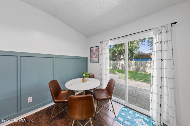 1501 Cove Landing Dr, Jacksonville, FL 32233 - dining space featuring lofted ceiling, a decorative wall, wood finished floors, a textured ceiling, and wainscoting