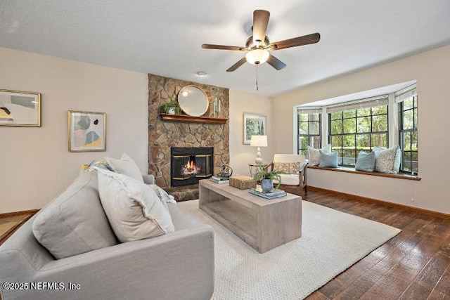 2768 N Periwinkle Ave, Middleburg, FL 32068 - living room with a ceiling fan, wood finished floors, a stone fireplace, and baseboards