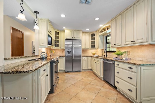 2768 N Periwinkle Ave, Middleburg, FL 32068 - kitchen featuring appliances with stainless steel finishes, a sink, cream cabinetry, stone countertops, and recessed lighting
