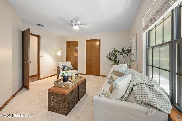 2768 N Periwinkle Ave, Middleburg, FL 32068 - living room with a ceiling fan, light colored carpet, and baseboards