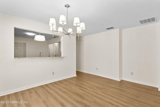 96002 Coral Reef Rd, Yulee, FL 32097 - spare room featuring wood finished floors, baseboards, a chandelier, and a sink