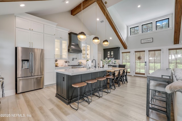 10351 County Road 13 N, Saint Augustine, FL 32092 - kitchen featuring stainless steel fridge, premium range hood, beam ceiling, light countertops, and a kitchen bar