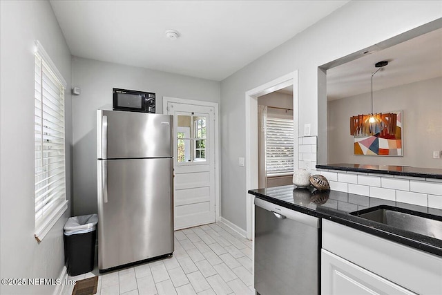 1838 Cherry St, Jacksonville, FL 32205 - kitchen with appliances with stainless steel finishes, dark countertops, white cabinets, backsplash, and light tile patterned floors