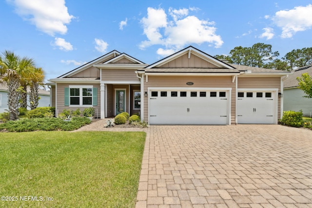 96167 Grande Oaks Ln, Fernandina Beach, FL 32034 - craftsman house with decorative driveway, an attached garage, a front lawn, and board and batten siding