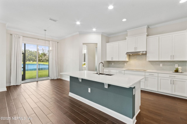 96167 Grande Oaks Ln, Fernandina Beach, FL 32034 - kitchen featuring a sink, under cabinet range hood, crown molding, black electric stovetop, and baseboards