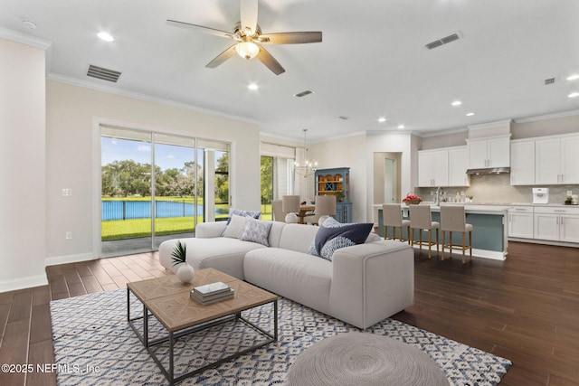 96167 Grande Oaks Ln, Fernandina Beach, FL 32034 - living room with dark wood-type flooring, ornamental molding, a chandelier, baseboards, and a ceiling fan