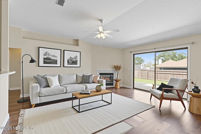 639 English Meadows Ct, Orange Park, FL 32073 - living area with a textured ceiling, a ceiling fan, wood finished floors, baseboards, and a glass covered fireplace