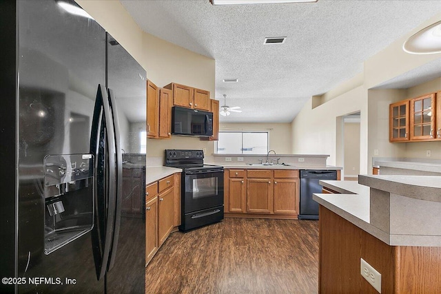 639 English Meadows Ct, Orange Park, FL 32073 - kitchen featuring black appliances, a sink, dark wood finished floors, a peninsula, and brown cabinetry