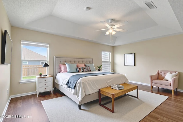 639 English Meadows Ct, Orange Park, FL 32073 - bedroom featuring a tray ceiling, multiple windows, and dark wood-style flooring