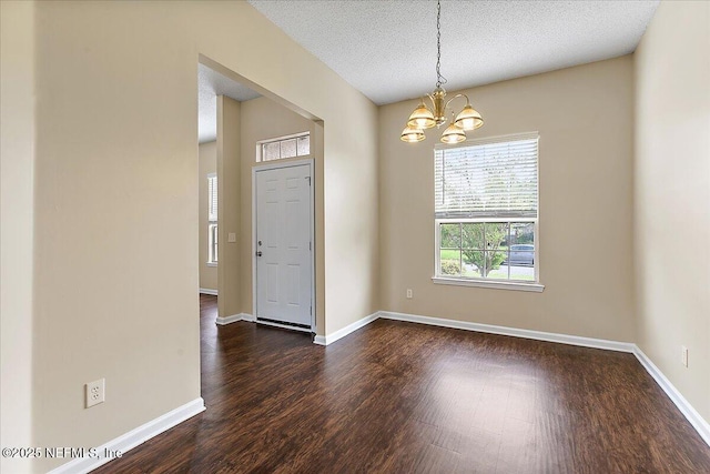 5631 Ortega Park Blvd, Jacksonville, FL 32244 - empty room featuring a chandelier, dark wood-style floors, baseboards, and a textured ceiling