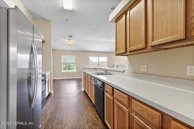 5631 Ortega Park Blvd, Jacksonville, FL 32244 - kitchen with stainless steel appliances, a sink, dark wood finished floors, brown cabinets, and a textured ceiling