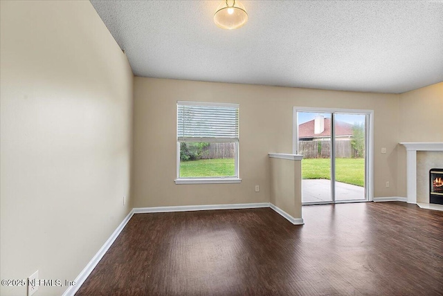 5631 Ortega Park Blvd, Jacksonville, FL 32244 - unfurnished living room with wood finished floors, a tile fireplace, healthy amount of natural light, a textured ceiling, and baseboards