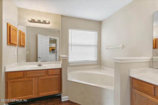 5631 Ortega Park Blvd, Jacksonville, FL 32244 - full bath featuring vanity, a garden tub, a textured ceiling, and wood finished floors