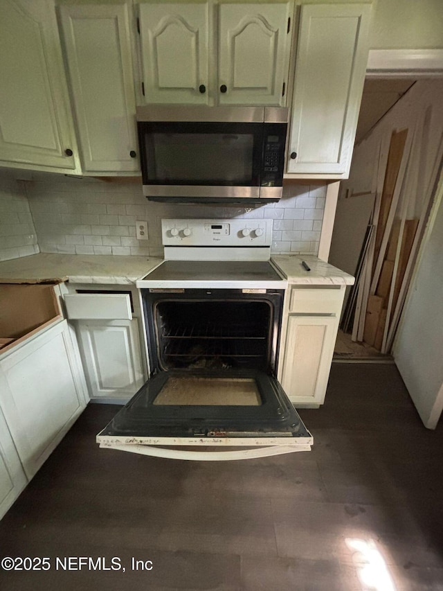 1630 Steele St, Jacksonville, FL 32209 - kitchen with stainless steel microwave, white range with electric stovetop, backsplash, and light countertops