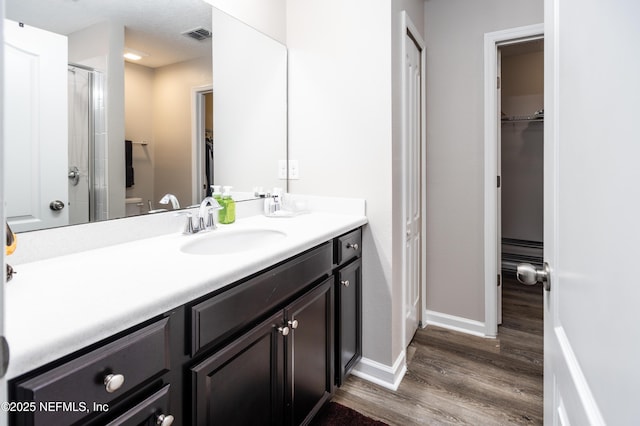 2538 Las Calinas Blvd, Saint Augustine, FL 32095 - full bath with vanity, a spacious closet, wood finished floors, a shower with shower door, and baseboards