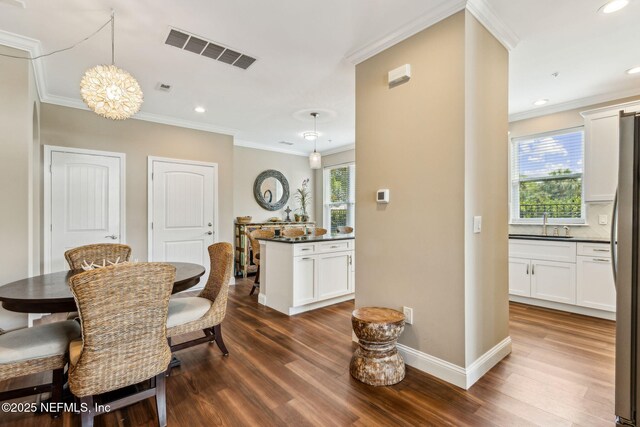 1899 White Sands Way Unit 704, Fernandina Beach, FL 32034 - dining space with dark wood finished floors, crown molding, baseboards, a chandelier, and recessed lighting