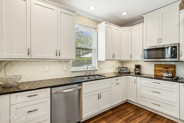 1899 White Sands Way Unit 704, Fernandina Beach, FL 32034 - kitchen featuring appliances with stainless steel finishes, a sink, dark countertops, dark wood-type flooring, and white cabinets