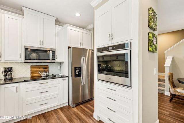 1899 White Sands Way Unit 704, Fernandina Beach, FL 32034 - kitchen featuring stainless steel appliances, dark wood finished floors, decorative backsplash, white cabinets, and recessed lighting