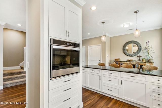 1899 White Sands Way Unit 704, Fernandina Beach, FL 32034 - kitchen featuring stainless steel oven, dark countertops, ornamental molding, white cabinetry, and dark wood-style flooring