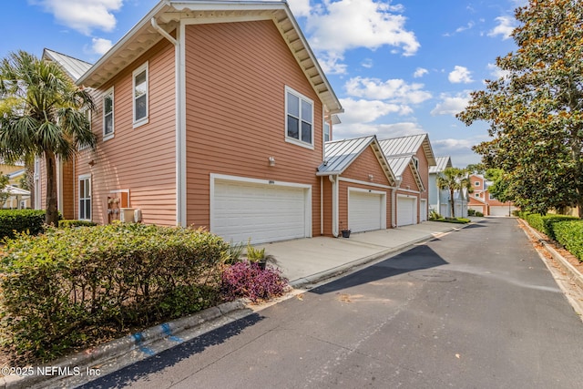1899 White Sands Way Unit 704, Fernandina Beach, FL 32034 - view of home's exterior with a standing seam roof, metal roof, an attached garage, a residential view, and concrete driveway