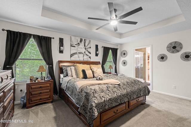 203 Buck Run Way, Saint Augustine, FL 32092 - bedroom with a tray ceiling, light carpet, ceiling fan, and connected bathroom