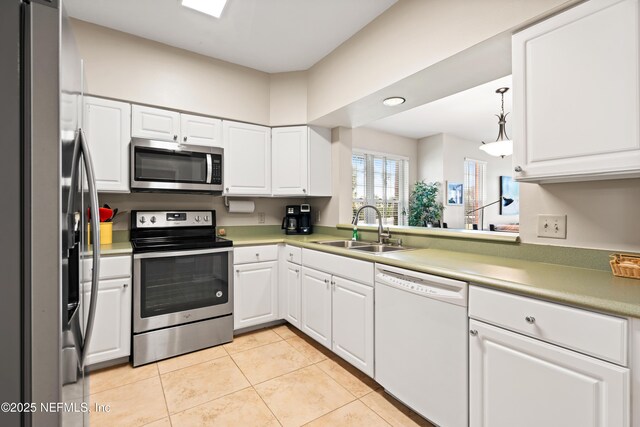 225 Atlantis Cir Unit 101-A, Saint Augustine Beach, FL 32080 - kitchen with appliances with stainless steel finishes, a sink, white cabinets, light tile patterned floors, and recessed lighting