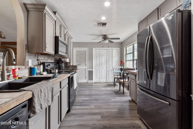 1942 Calusa Trl, Middleburg, FL 32068 - kitchen featuring stainless steel appliances, a sink, a textured ceiling, a ceiling fan, and tasteful backsplash