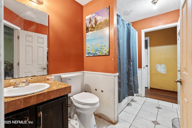 1942 Calusa Trl, Middleburg, FL 32068 - bathroom with toilet, wainscoting, vanity, tile patterned floors, and a textured ceiling