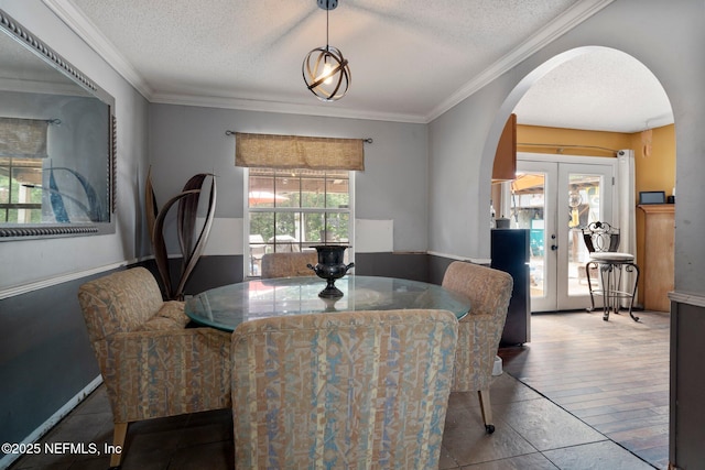 1942 Calusa Trl, Middleburg, FL 32068 - dining space with arched walkways, french doors, a textured ceiling, tile patterned flooring, and ornamental molding
